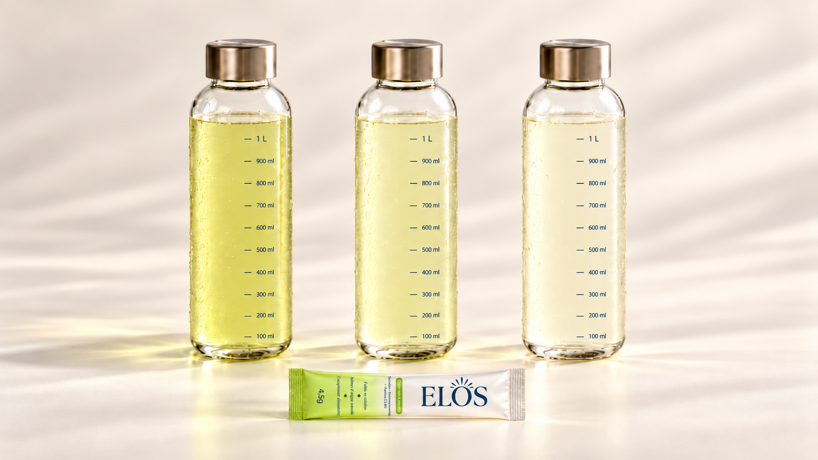 Trois bouteilles d'eau avec ELOS dilué à différentes intensités, de la plus prononcée à la plus légère, devant un stick ELOS citron vert & menthe